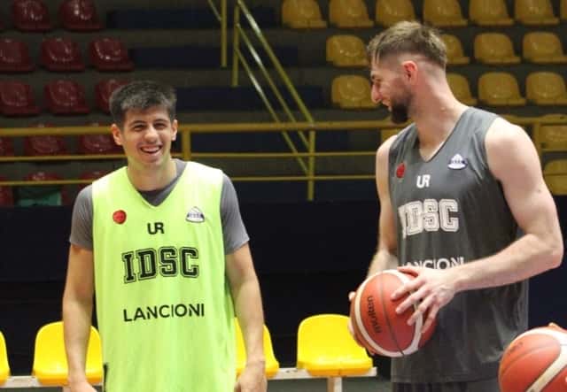 Un jugador de Independiente de Oliva, con musculosa verde flúor, sonríe con la pelota en las manos durante la práctica en Brasil