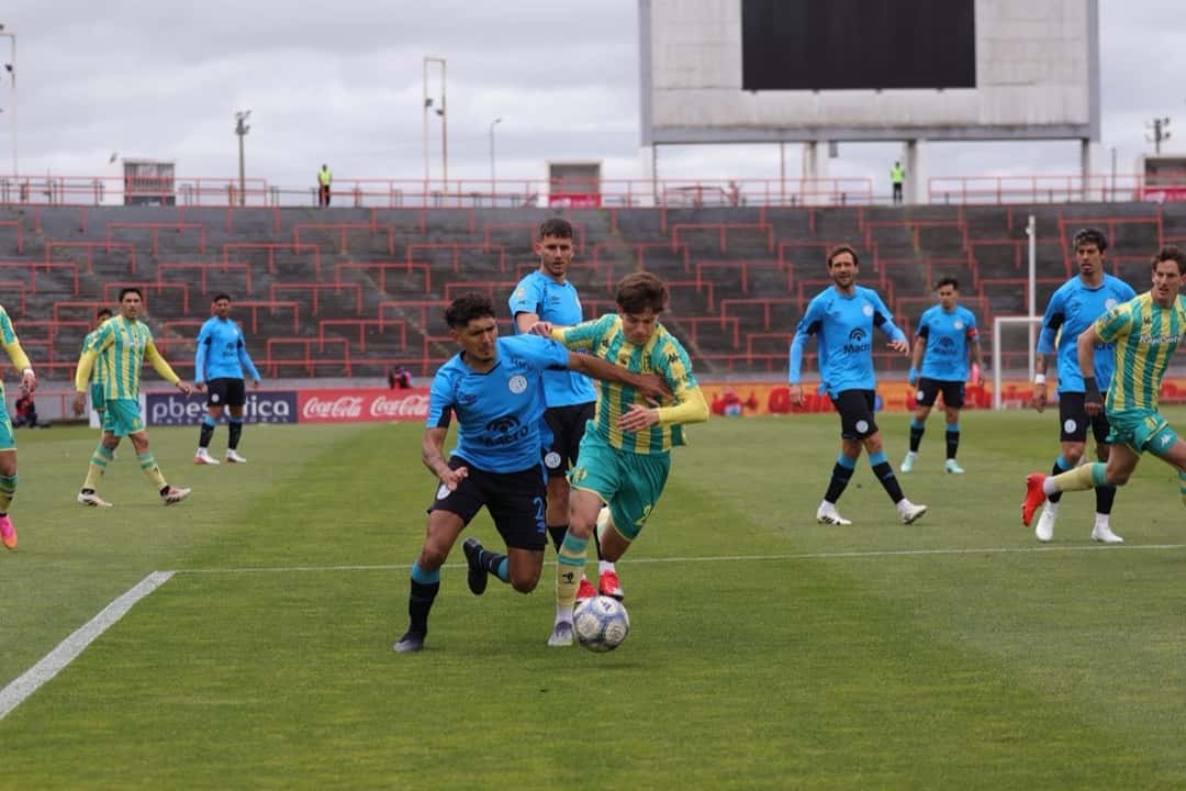 Jugadores de Aldosivi, con camiseta amarilla y verde, y un rival de camiseta celeste pelean la pelota en un partido del Torneo Clausura; foto de archivo de octubre de 2026 (foto: prensa Liga Profesional de Fútbol)
