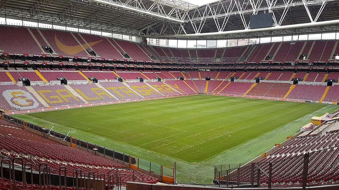 El estadio del Galatasaray vacío, con las butacas rojas y amarillas que forman el nombre del club en una de las cabeceras; foto de archivo de 2017 (foto: 1886kusagi, Wikimedia Commons, licencia CC BY-SA 4.0)