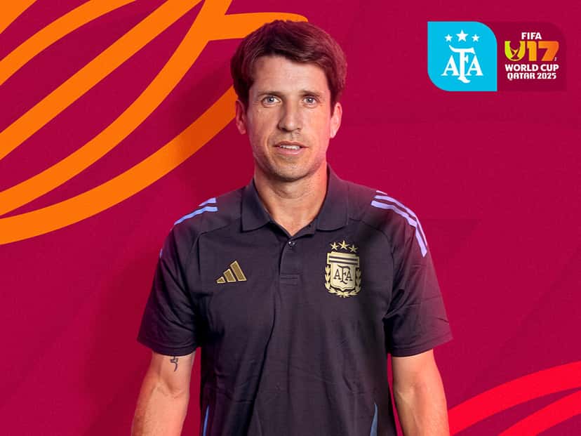 Diego Placente, entrenador de la Selección argentina Sub-17, posa con la ropa oficial de la AFA delante de un fondo con los colores del Mundial Sub-17 de Qatar 2025; foto de archivo (foto: prensa oficial de la AFA)