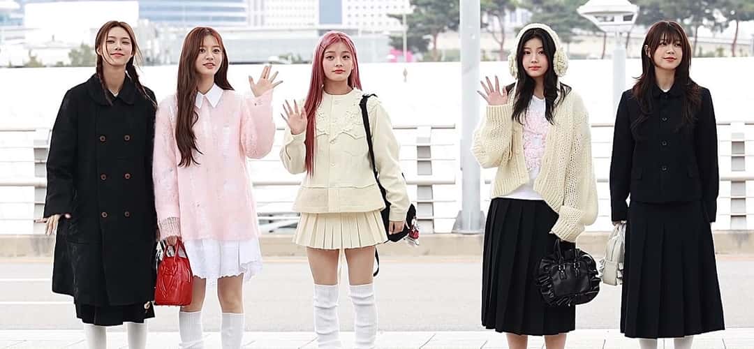 Las cinco integrantes de ILLIT saludan con la mano en el aeropuerto de Incheon, con ropa de invierno en tonos negros, rosa y crema (foto de archivo, noviembre de 2024). Foto: K-POPIT, CC BY 3.0, vía Wikimedia Commons