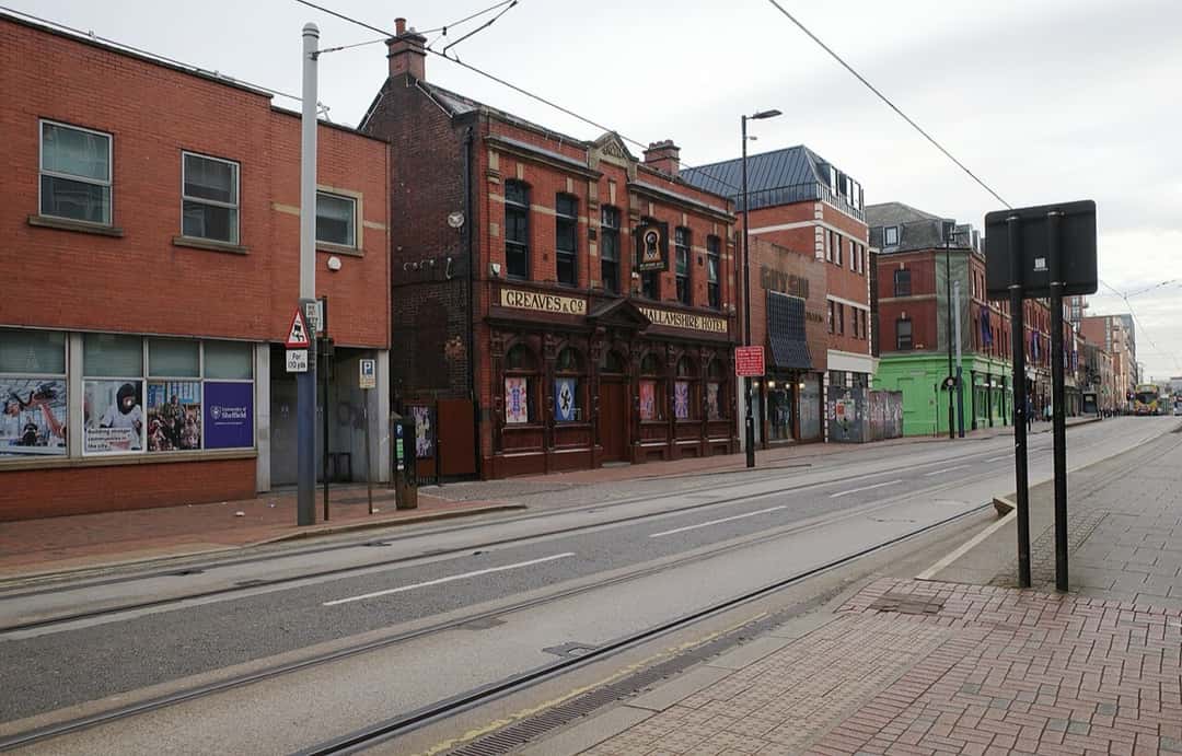 Fachada de ladrillo rojo del Hallamshire Hotel, en West Street, Sheffield, con el cartel «Greaves & Co» y las vías del tranvía en primer plano (foto de archivo, octubre de 2025). Foto: habiloid, CC BY-SA 2.0, vía geograph.org.uk y Wikimedia Commons