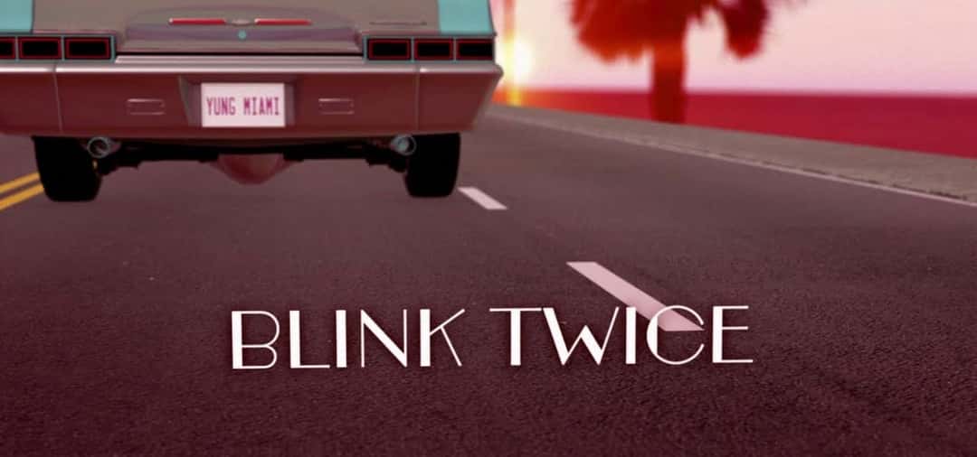Arte del lyric video de «Blink Twice»: la parte trasera de un auto clásico celeste con la patente «YUNG MIAMI» sobre una ruta, con el título de la canción en letras blancas