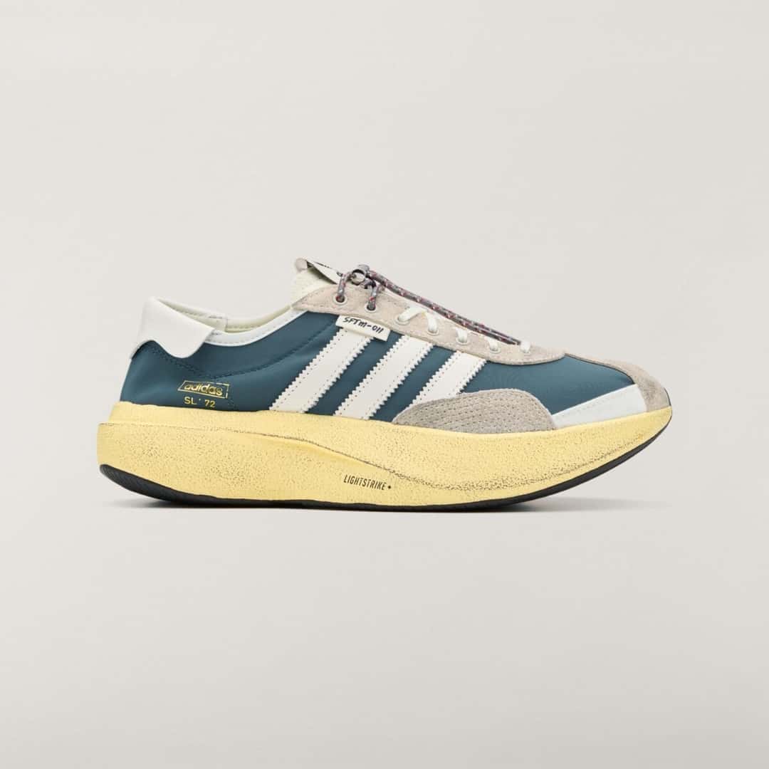 Vista lateral del adidas SL 72 PRO Wild Teal de Song for the Mute, con capellado textil verde azulado, tres tiras blancas dentadas, puntera y talón de gamuza gris, cordón con toggle, etiqueta SFTM-011 y mediasuela alta amarilla con la inscripción Lightstrike+
