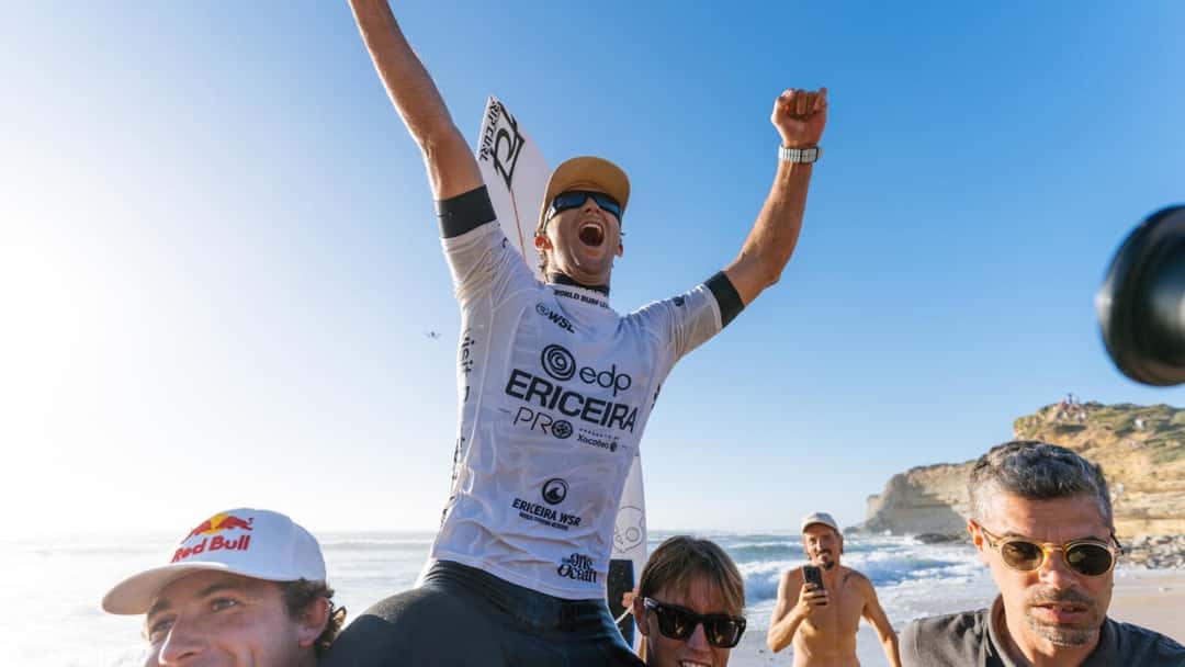 Crosby Colapinto, con la lycra blanca del EDP Ericeira Pro, grita y levanta los brazos llevado en andas por la playa, con el acantilado de Ribeira d'Ilhas de fondo