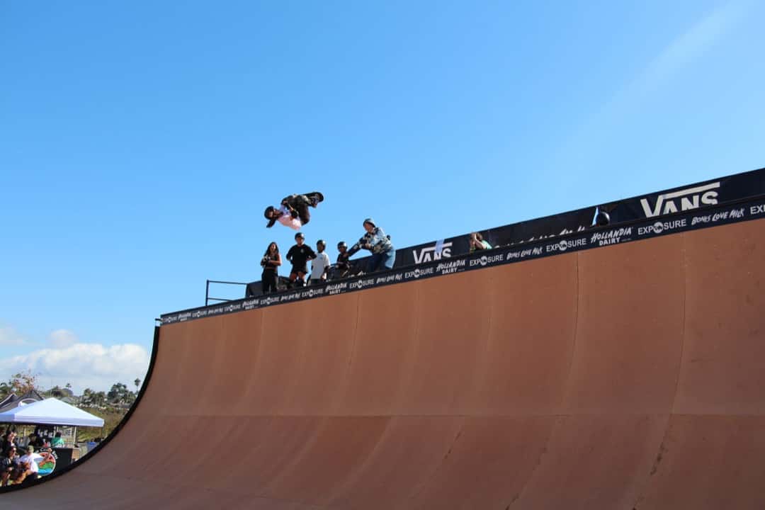 Foto de archivo: una skater vuela por encima del borde de la rampa de vert de Exposure 2024, con el cielo azul de fondo