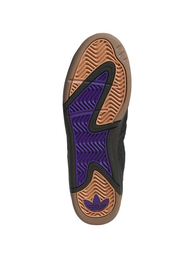 Suela del adidas Kader negro vista desde abajo, con goma color caramelo en la punta y el talón, un sector central violeta, dibujo de tracción en espiga y el Trefoil violeta en el talón