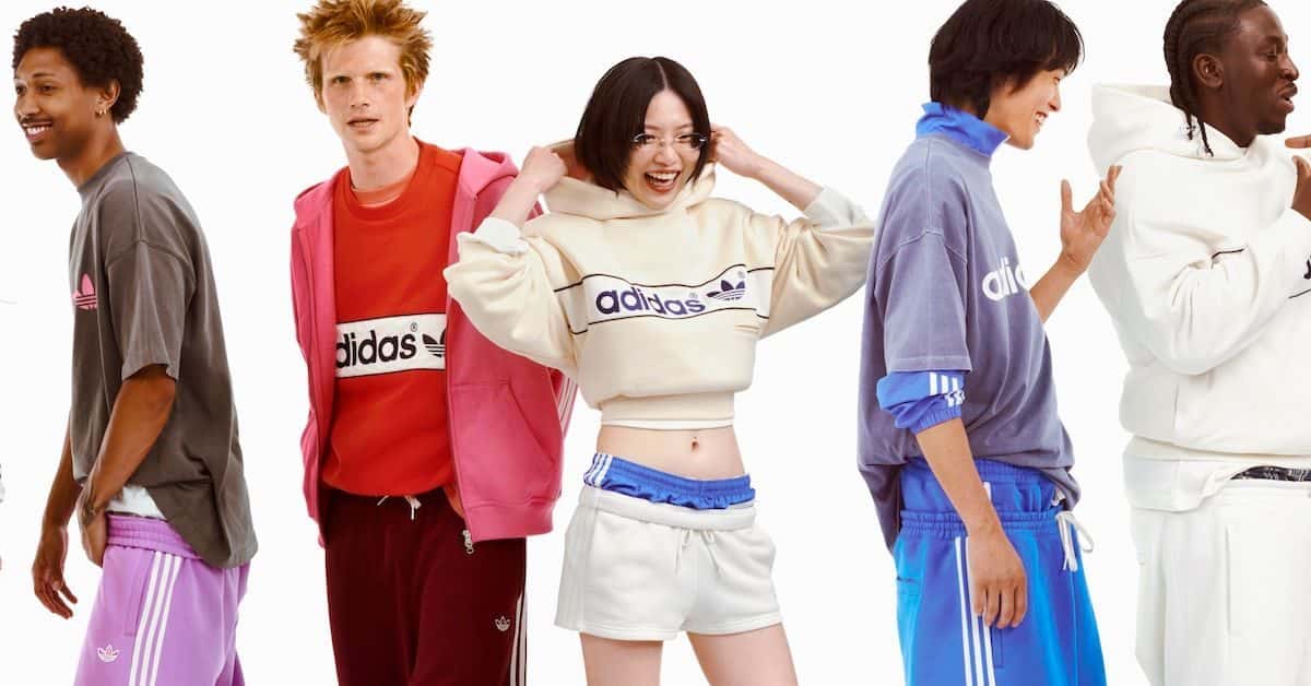 Cinco personas con prendas de la colección adiSignature de adidas Originals: buzos con el logo de adidas, una campera rosa, un buzo crema corto y joggings con tres tiras en lila, bordó y azul