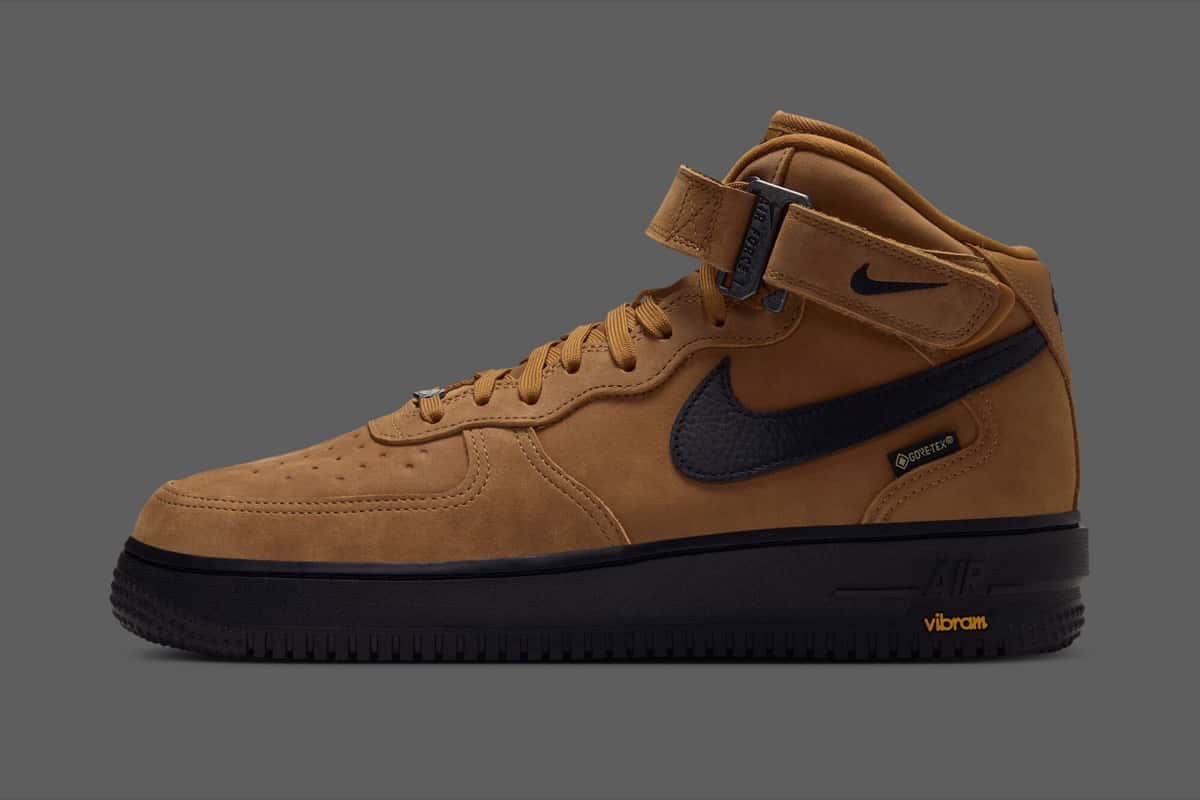 Nike Air Force 1 Mid GORE-TEX Vibram color trigo de perfil sobre fondo gris, con Swoosh negro, suela negra y el logo de Vibram en amarillo