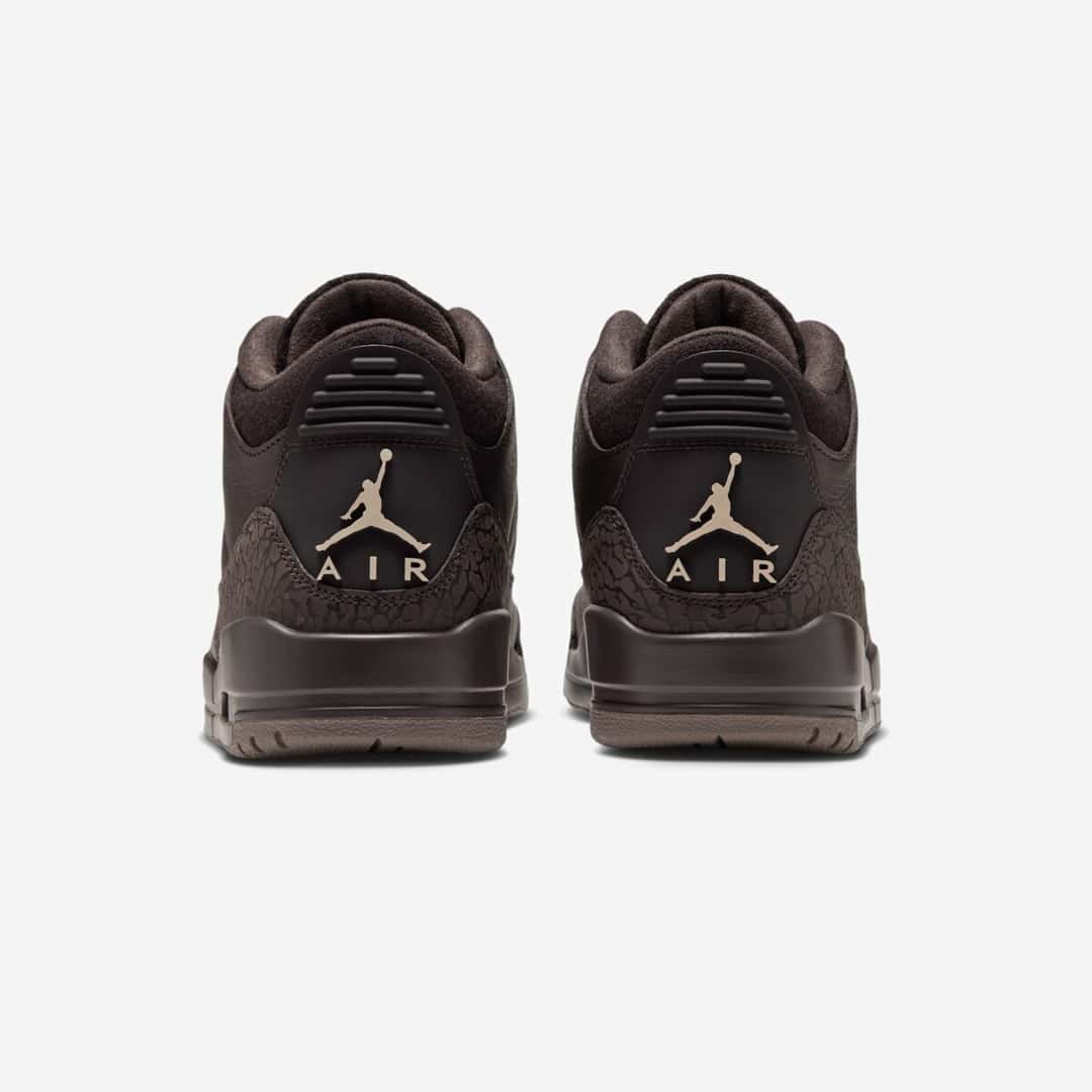 Vista trasera de un par de Air Jordan 3 Fireside marrones, con el Jumpman y la palabra AIR en beige en cada talón, elephant print marrón alrededor y suela marrón