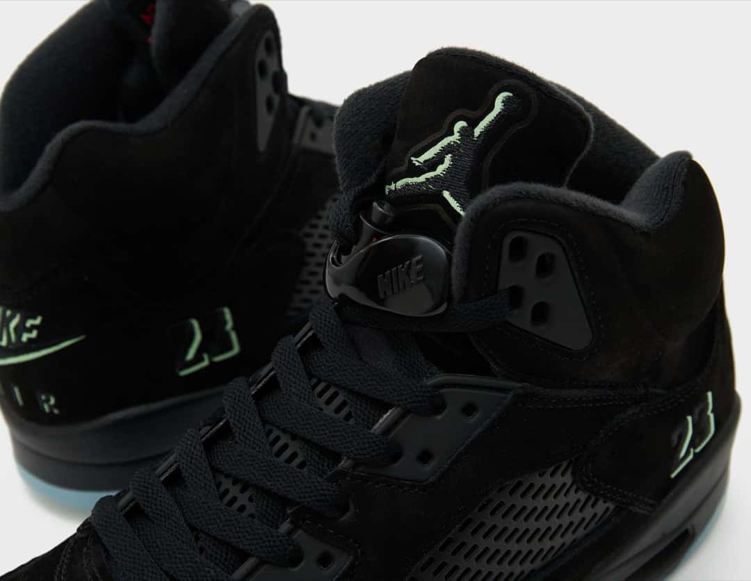 Detalle del Air Jordan 5 Halloween con el Jumpman de la lengüeta, el 23 bordado y el Nike Air del talón en verde fosforescente sobre gamuza negra