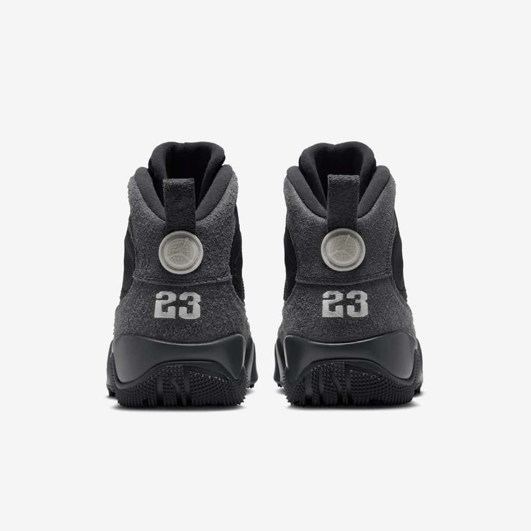 Vista trasera del par del Air Jordan 9 Retro Boot NRG Anthracite sobre fondo blanco, con la gamuza gris oscura, el número 23 en gris claro sobre cada talón, el disco con el logo arriba y la suela negra con tacos