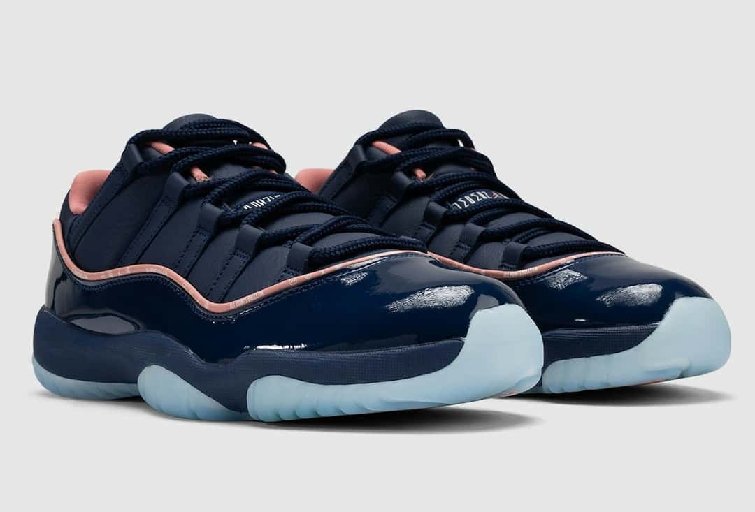 Par de APB x Air Jordan 11 Low Made for Locals en vista de tres cuartos sobre fondo gris claro, con el charol azul brillante, el vivo rosa y la suela translúcida celeste