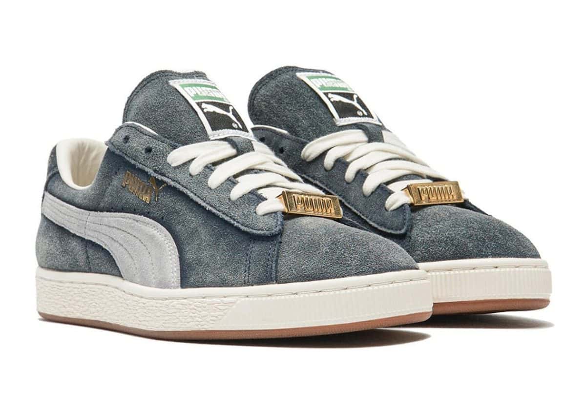 Par de A$AP Rocky x PUMA Suede '94 Faded Blue sobre fondo blanco, con gamuza azul desteñida, Formstrip gris, cordones blancos, chapita dorada en los cordones y mediasuela blanca
