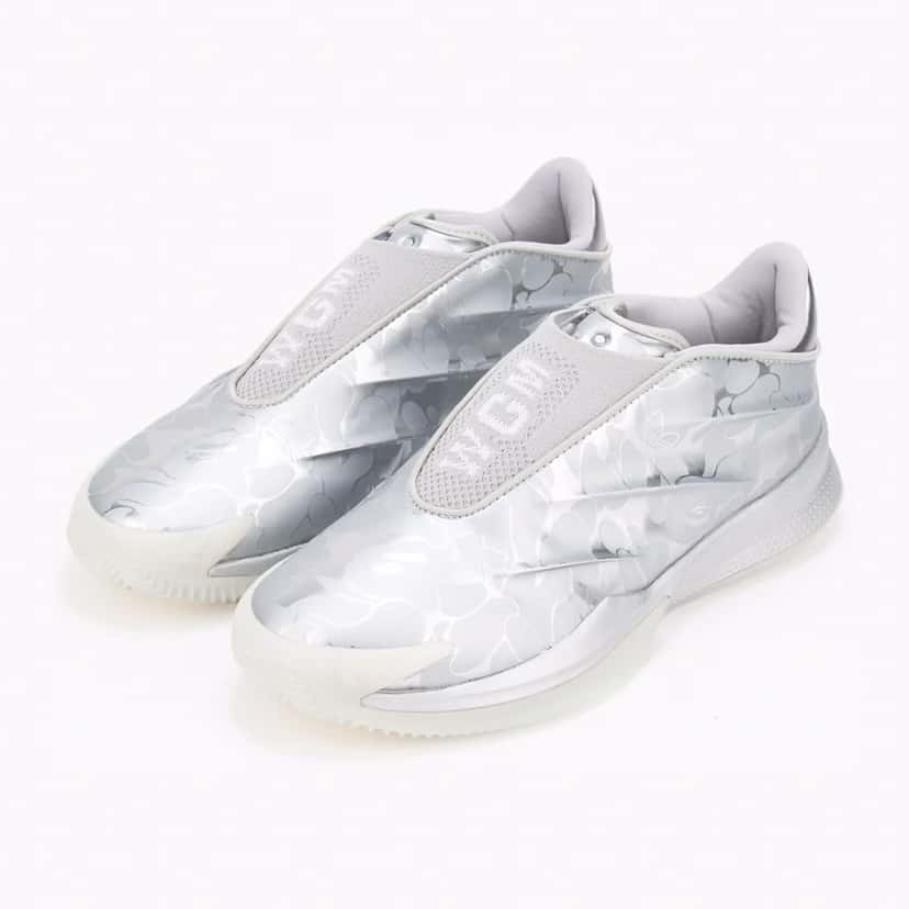 Par de la BAPE x adidas Crazy Energy+ plateada en vista de tres cuartos, con la sigla WGM sobre la tapa del empeine y el camuflaje ABC en tonos de plata