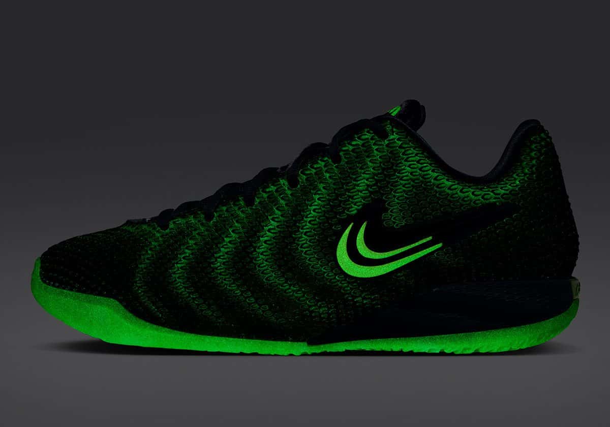 Nike Caitlin 1 Jinx de perfil a oscuras, con la suela, el Swoosh y las líneas del upper brillando en verde