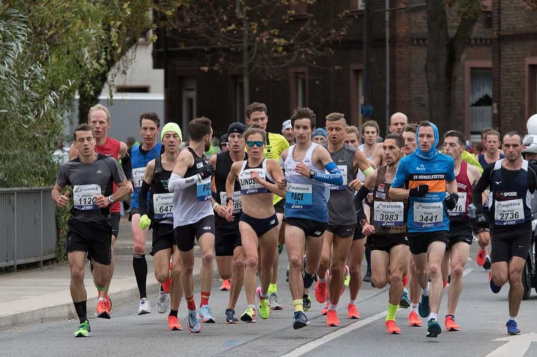 Foto de archivo: un grupo numeroso de corredores avanza por una calle arbolada durante el Maratón de Frankfurt 2018