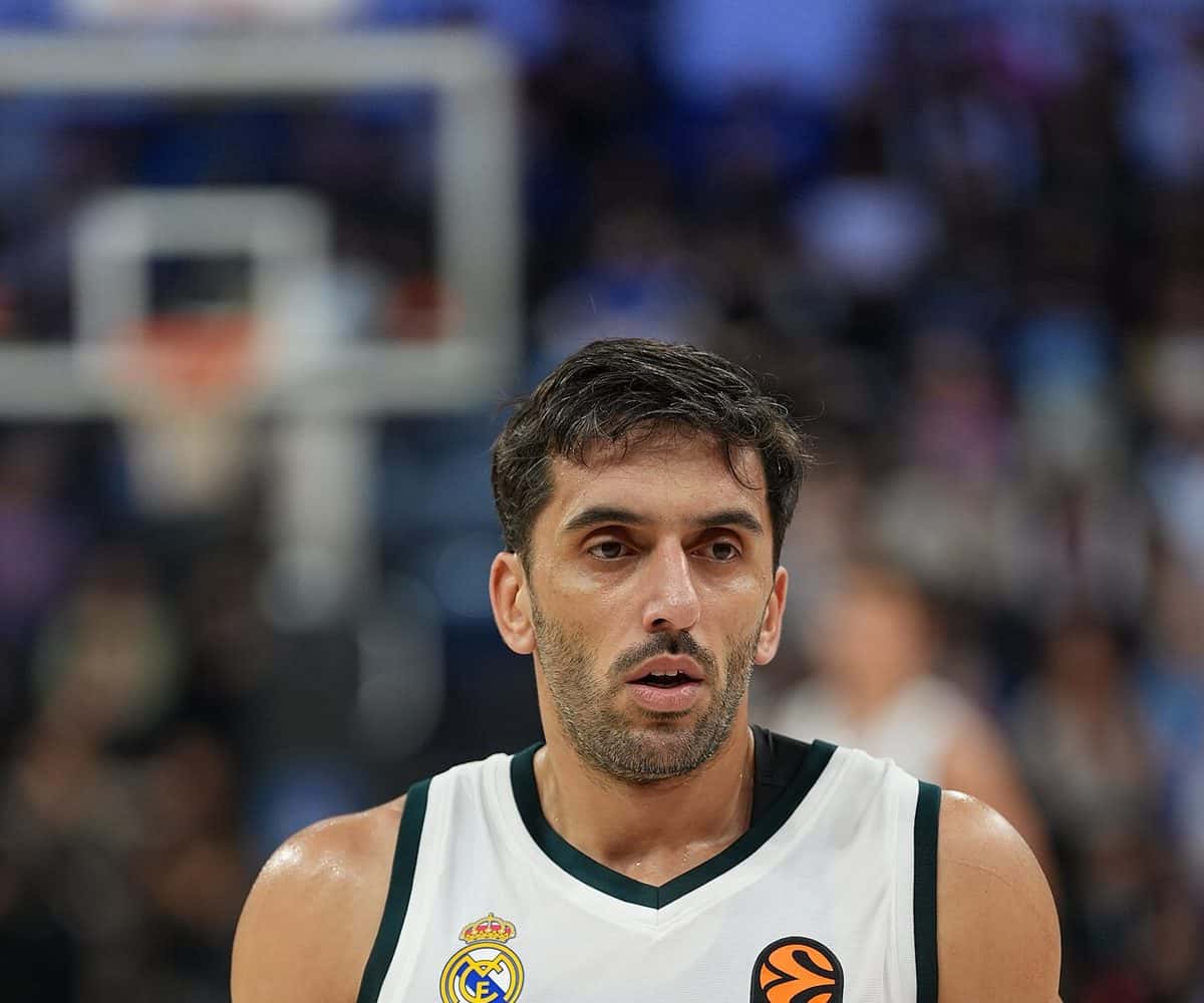 Foto de archivo: Facundo Campazzo, con la camiseta blanca número 7 del Real Madrid, mira hacia un costado durante un partido de Euroliga, con el aro desenfocado detrás