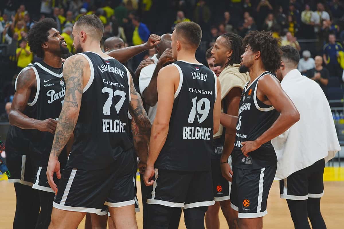 Foto de archivo: jugadores del Partizan, con la camiseta negra, reunidos en ronda en la cancha durante un partido de Euroliga