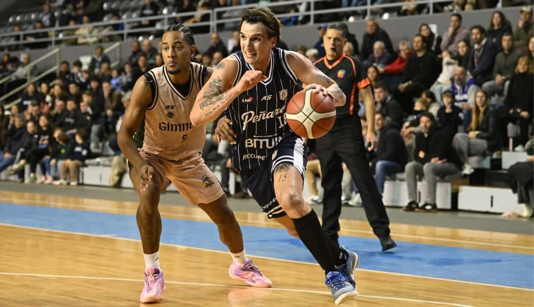 Un jugador de Peñarol con la pelota supera la marca de un rival de Gimnasia de Comodoro en Mar del Plata