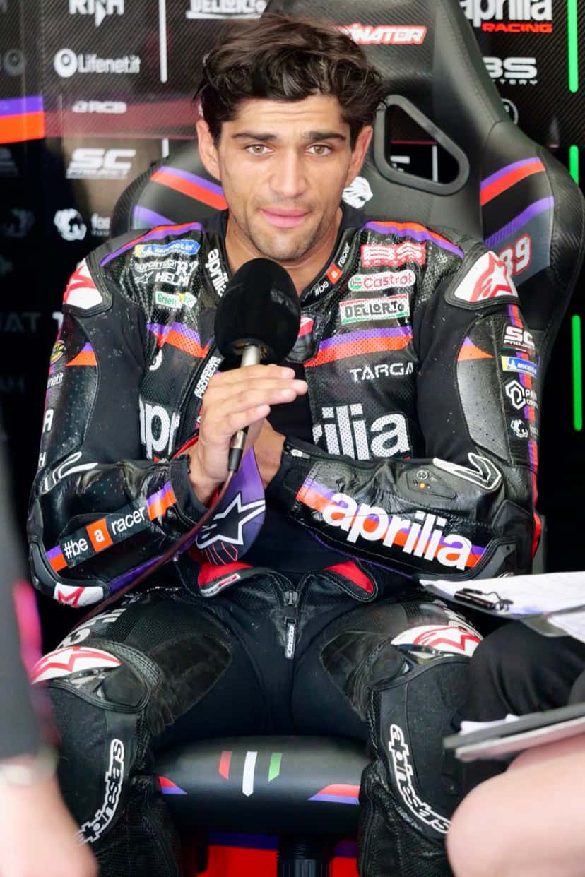 Foto de archivo: Jorge Martín, con el buzo negro de Aprilia Racing, habla sentado en el box con un micrófono en la mano