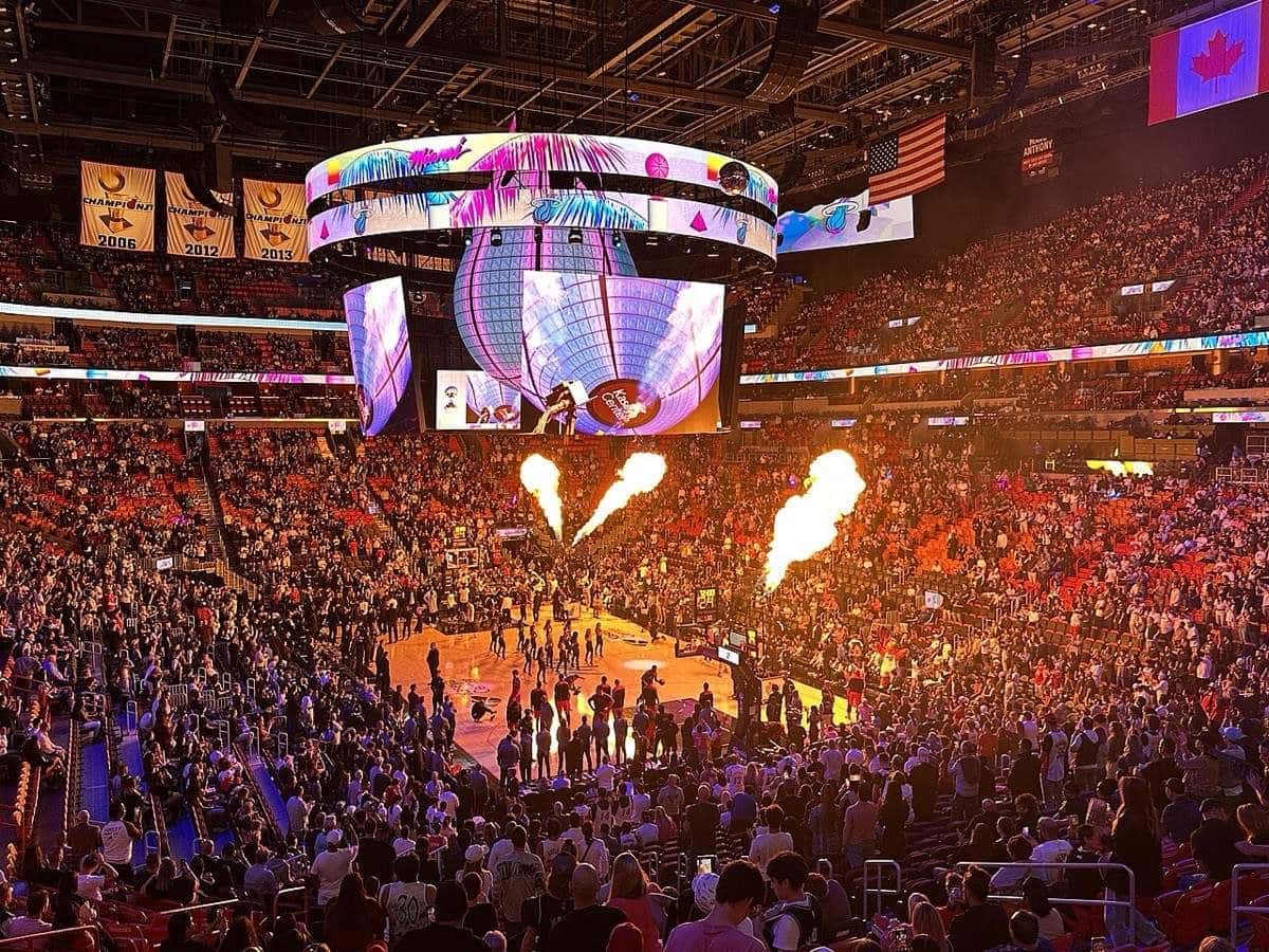 Foto de archivo: el Kaseya Center de Miami lleno antes de un partido del Heat, con llamaradas en la cancha, el marcador central encendido y los banners de campeón colgados del techo