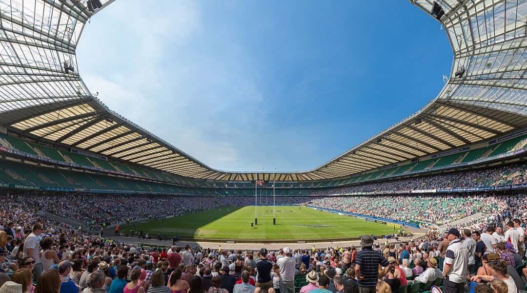 Vista panorámica del estadio de Twickenham, con las tribunas llenas de público y la cancha de rugby al centro bajo el cielo celeste