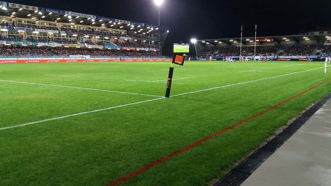 Foto de archivo: el estadio Pierre-Fabre de Castres de noche, con las tribunas iluminadas y un banderín del córner en primer plano, en 2017