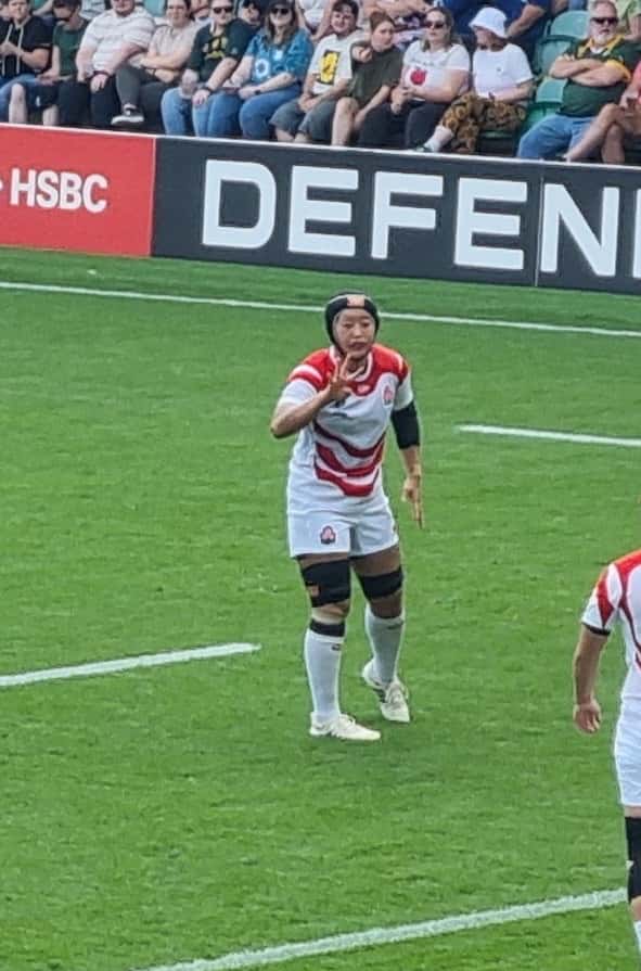 Foto de archivo: Yuna Sato, de Japón, con la camiseta blanca y roja y casco, en la cancha durante un partido del Mundial femenino 2025, con la tribuna detrás