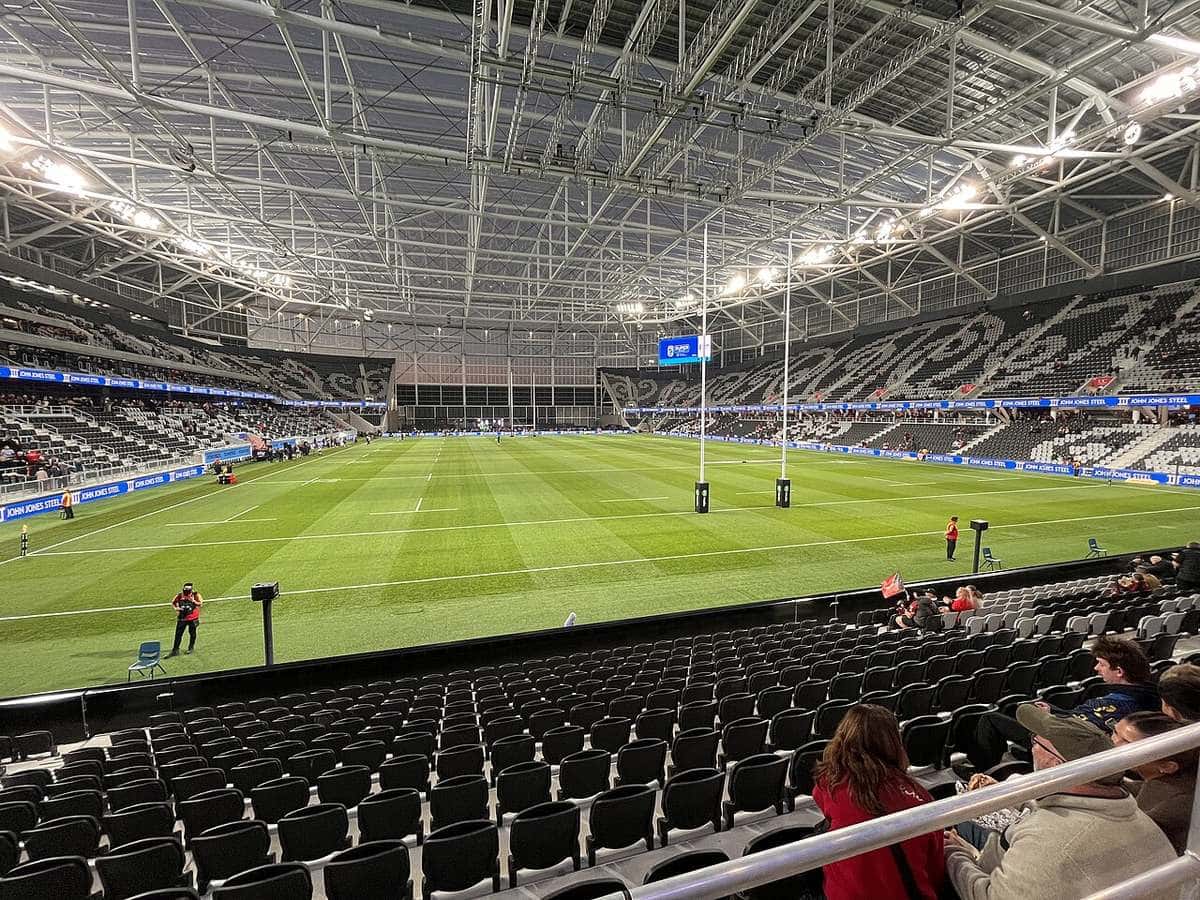 Imagen del estadio Te Kaha de Christchurch por dentro: la cancha de césped con las haches, las tribunas y el techo transparente iluminado