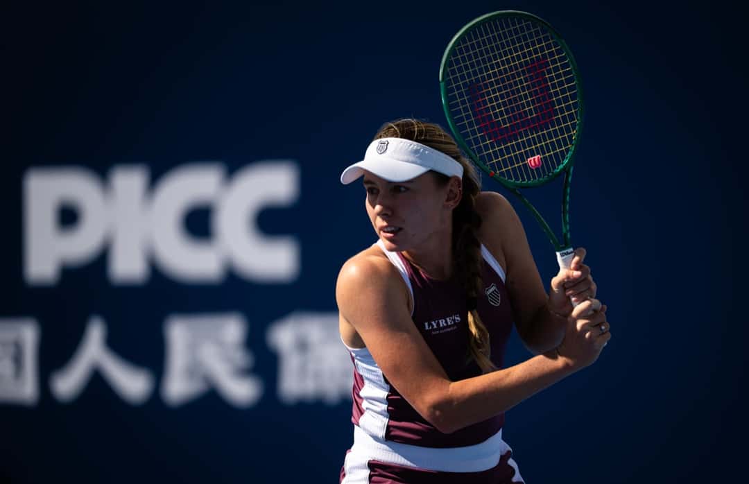 Ekaterina Alexandrova, con visera blanca y musculosa bordó, prepara un revés en la tercera ronda del China Open 2026 (foto de archivo)
