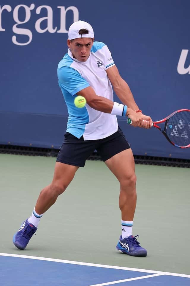 Foto de archivo: Sebastián Báez, con gorra blanca y remera celeste y blanca, pega un revés de dos manos en el US Open