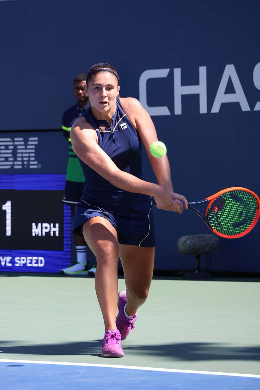 Foto de archivo: Julia Riera, con vestido azul oscuro, le pega un revés a dos manos en una cancha dura del US Open 2023