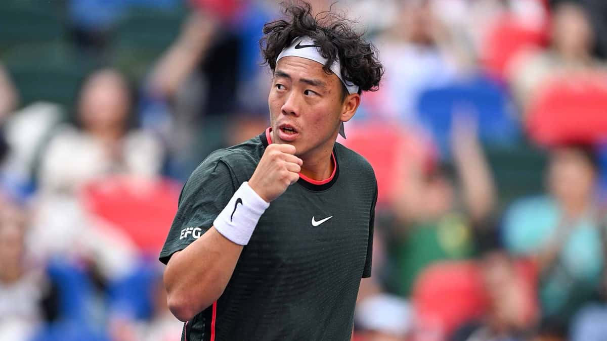 Coleman Wong, con vincha blanca y remera verde oscura, aprieta el puño para festejar un punto en la clasificación del Rolex Shanghai Masters, con la tribuna desenfocada detrás