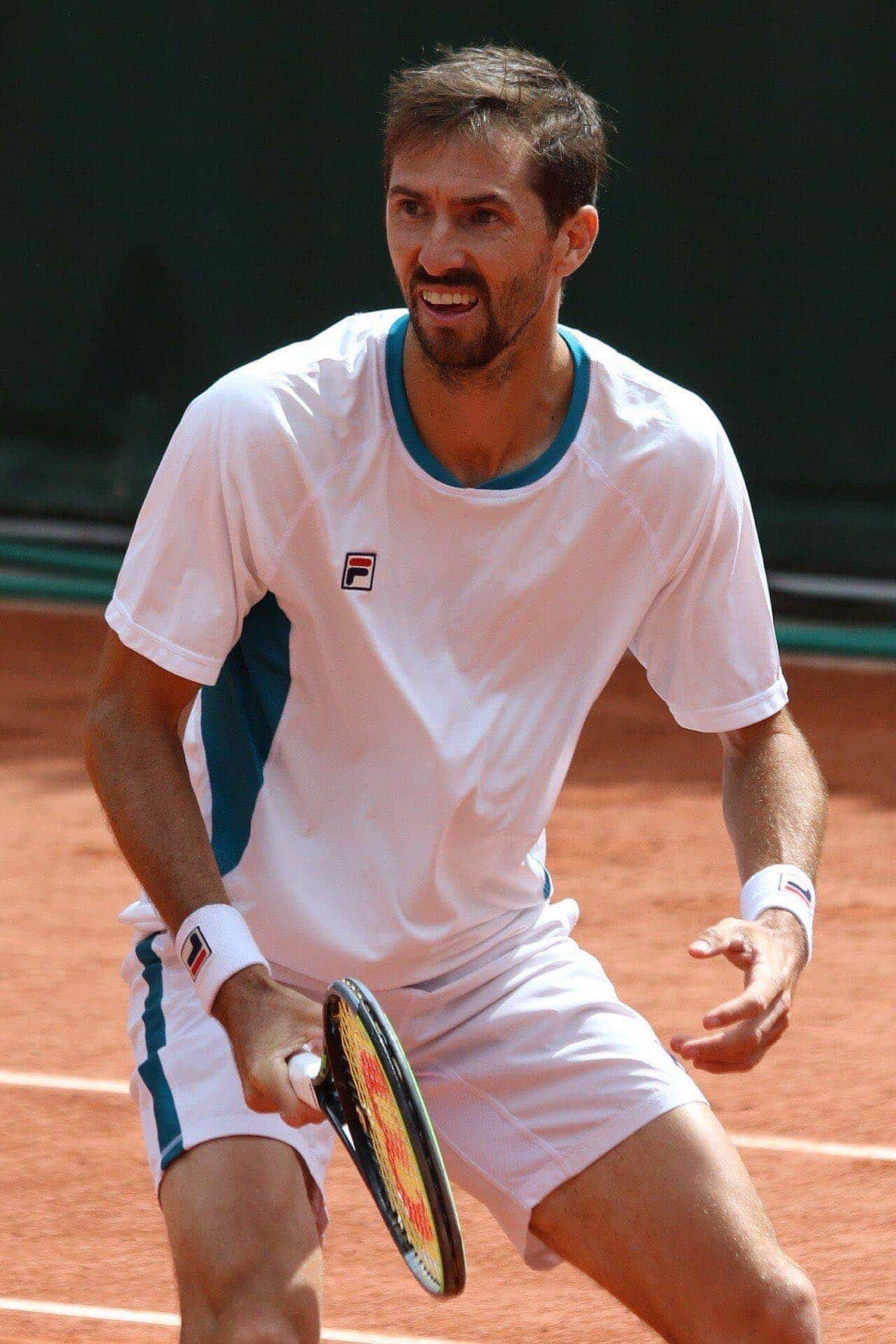 Foto de archivo: Andrés Molteni, con remera blanca, espera la devolución en posición de dobles sobre polvo de ladrillo en Roland Garros 2022