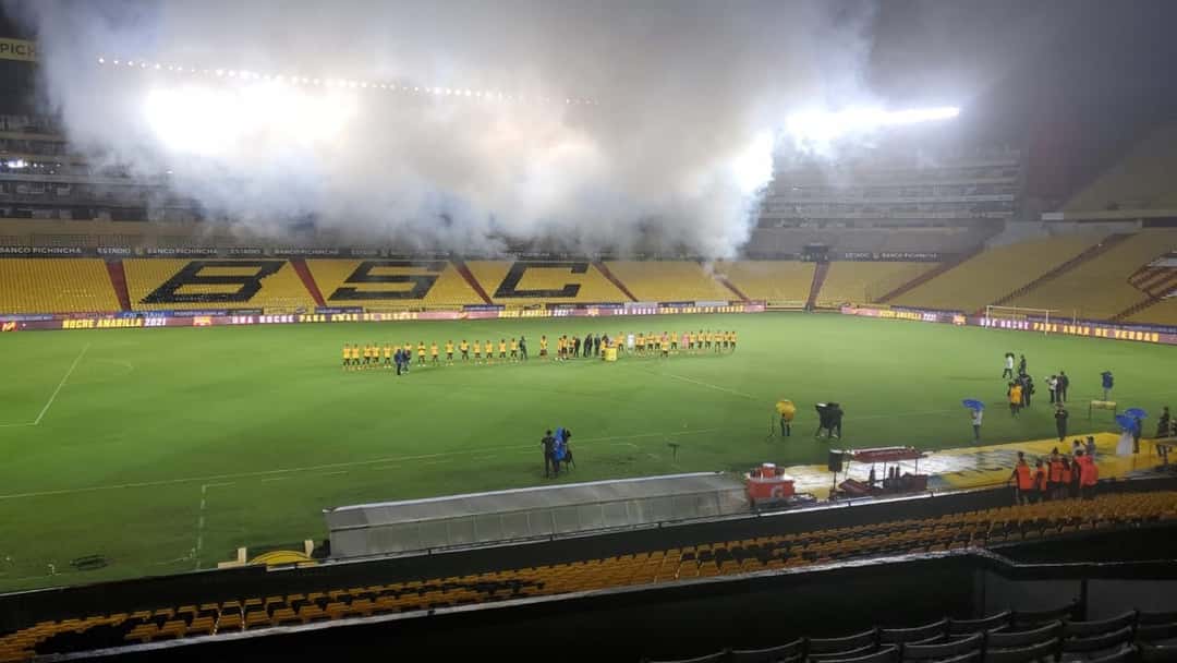 El plantel y el cuerpo técnico del Barcelona SC, formados en la cancha del estadio Monumental de Guayaquil, entre humo y luces, durante la Noche Amarilla; foto de archivo de 2021 (foto: Phenomenal32, Wikimedia Commons, licencia CC BY-SA 4.0)