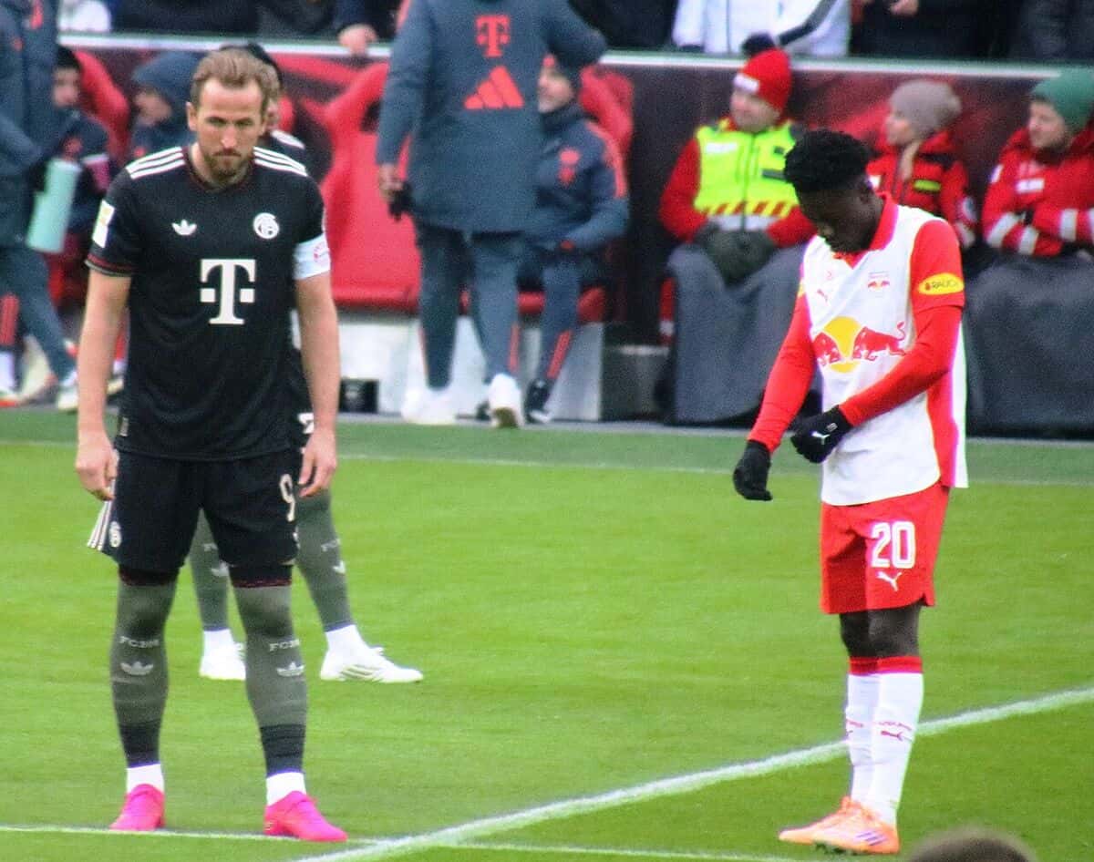 Harry Kane, con la camiseta negra del Bayern Múnich, el número 9 y la cinta de capitán, espera en el campo antes de un amistoso en Salzburgo; foto de archivo de enero de 2026 (foto: Werner100359, Wikimedia Commons, licencia CC BY-SA 4.0)