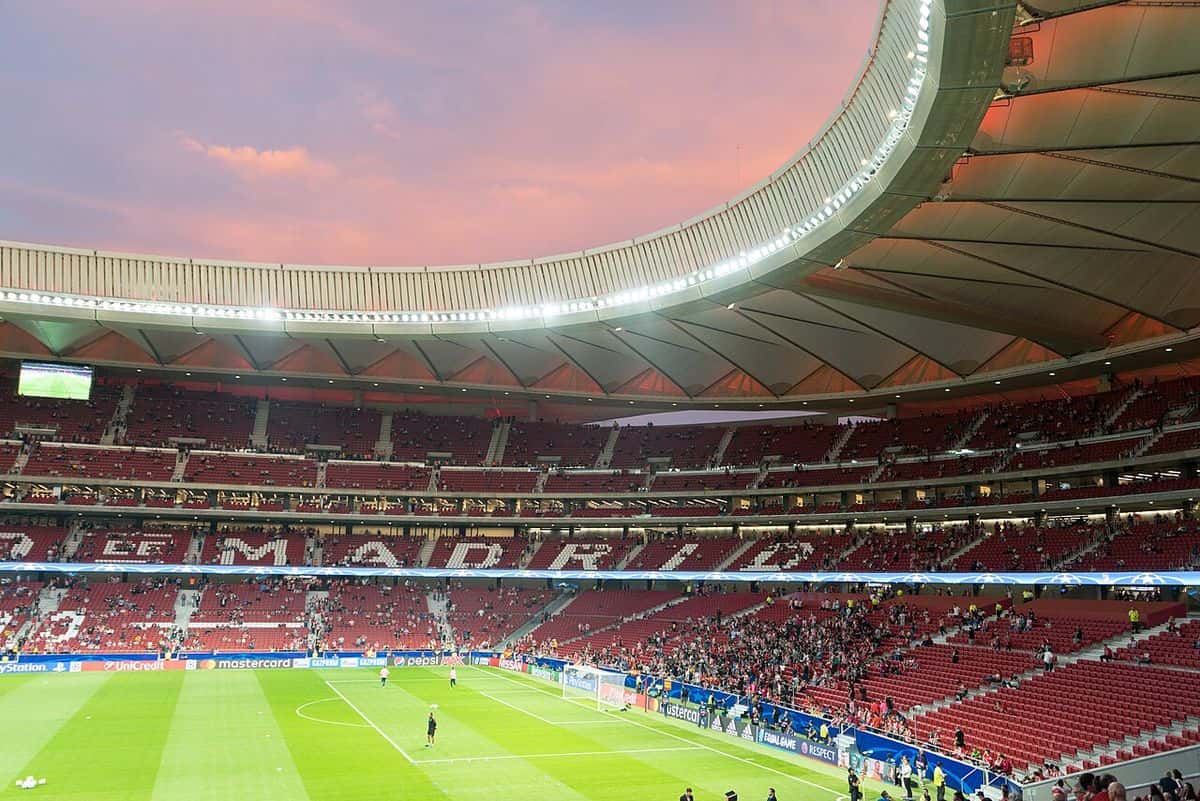 El interior del estadio Metropolitano, del Atlético de Madrid, con las tribunas rojas y el techo iluminado al atardecer, antes de un partido; foto de archivo de septiembre de 2017 (foto: Fabian Vidal, Wikimedia Commons, licencia CC BY-SA 4.0)
