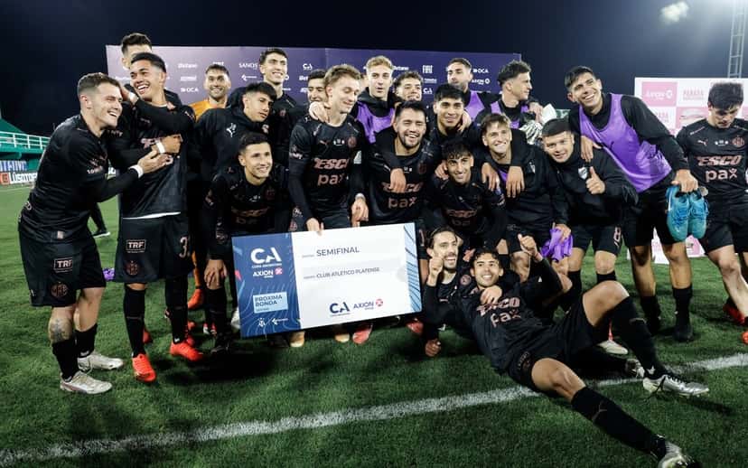 El plantel de Platense posa con el cartel oficial de la Copa Argentina que lo confirma en semifinales