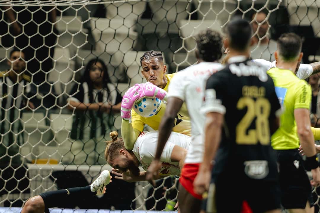 El arquero Gabriel Delfim, de amarillo, se queda con la pelota en el aire entre jugadores de Bragantino, de blanco, durante el partido en la Arena MRV (foto: prensa oficial de Atlético Mineiro)