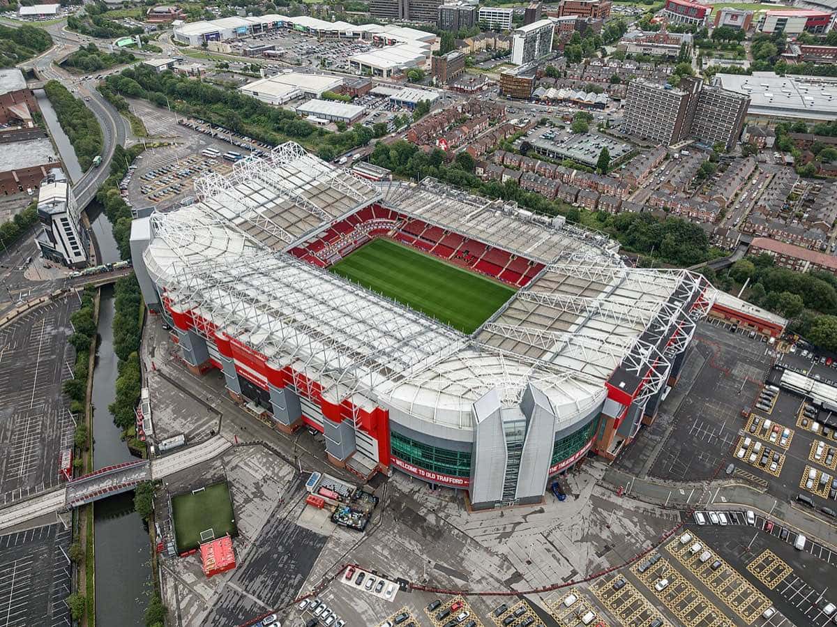 Vista aérea de Old Trafford, el estadio del Manchester United, con la cancha verde y las tribunas rojas bajo el techo blanco; foto de archivo de julio de 2023 (foto: Arne Müseler, Wikimedia Commons, licencia CC BY-SA 3.0 DE)