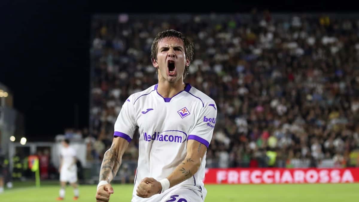 Franco Mastantuono grita un gol con la camiseta blanca de la Fiorentina, con los puños apretados y la tribuna de fondo; foto de archivo de esta temporada