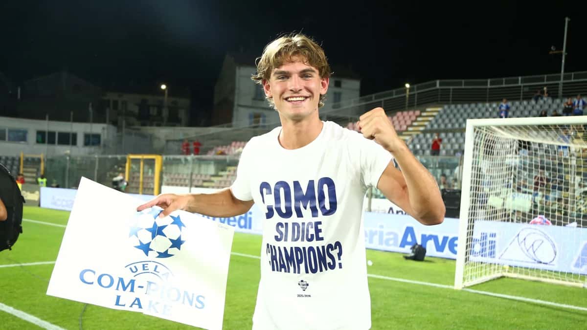 Nico Paz sonríe en la cancha con una remera del Como alusiva a la clasificación a la Champions League