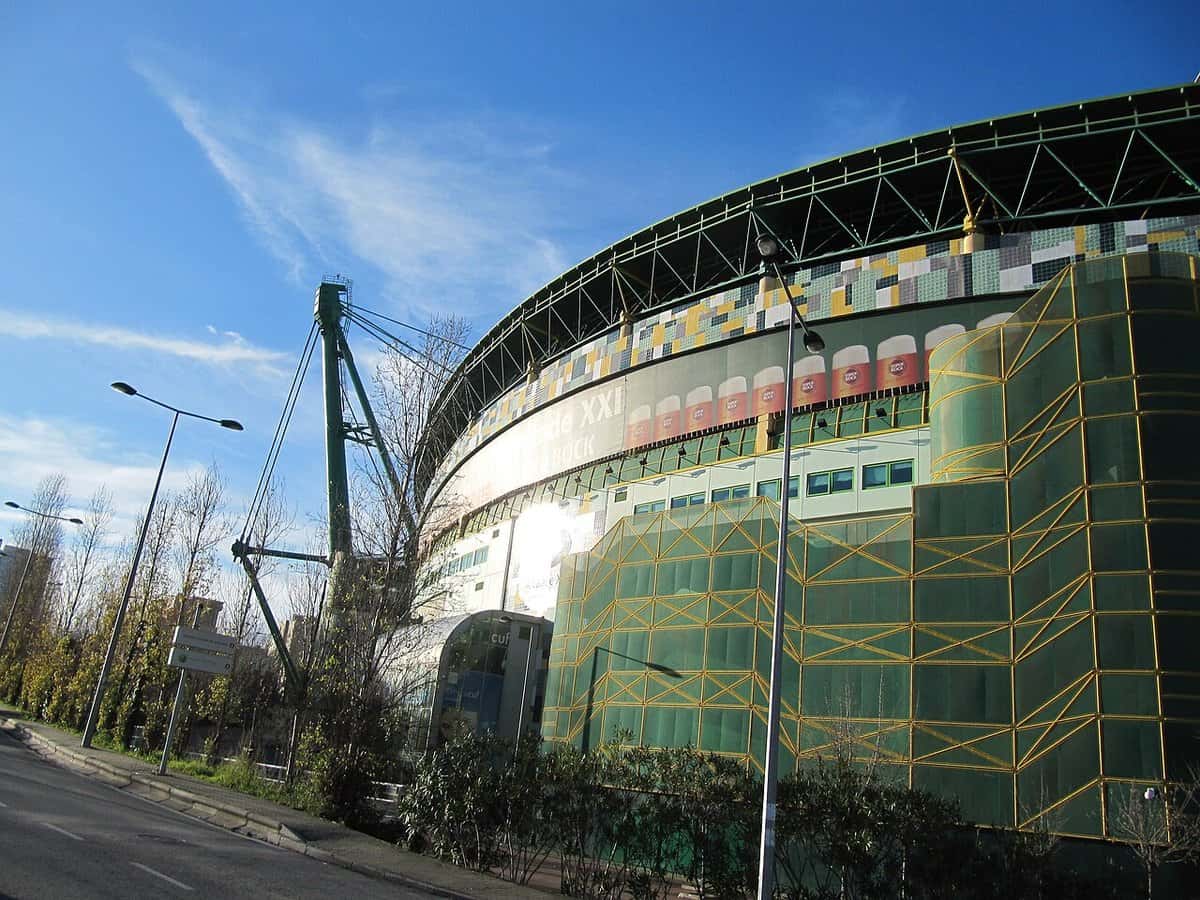 La fachada del estadio José Alvalade, del Sporting de Lisboa, con sus azulejos de colores y la estructura amarilla, bajo un cielo despejado; foto de archivo de 2014 (foto: jad99, Flickr, vía Wikimedia Commons, licencia CC BY-SA 2.0)