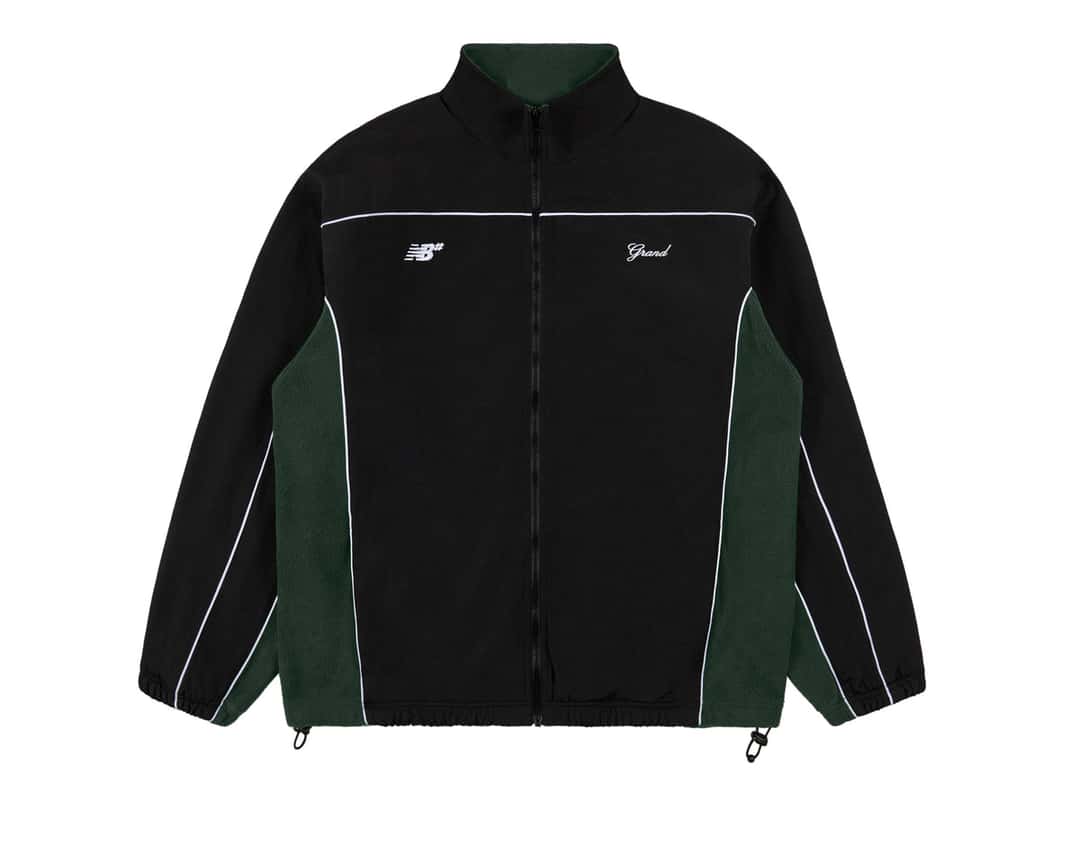 Campera de Grand Collection y New Balance Numeric sobre fondo blanco, de nylon negro con laterales de polar verde bosque, vivos blancos, cierre al frente y los logos NB# y Grand bordados en blanco en el pecho