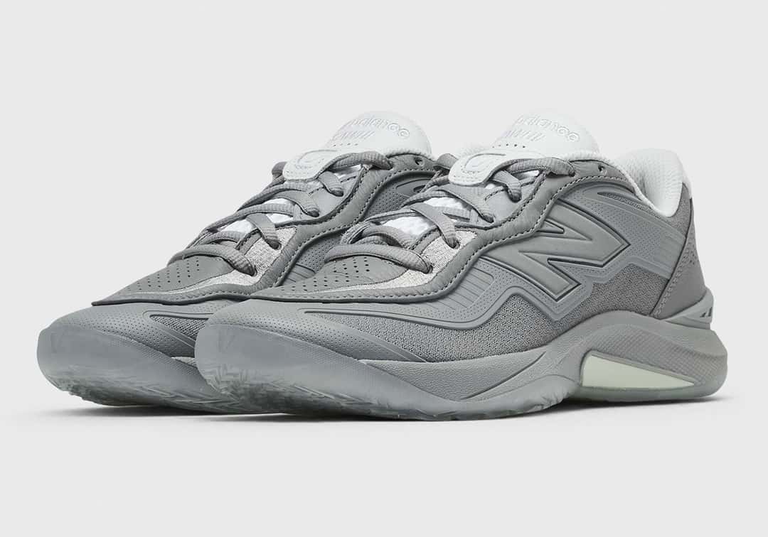 Par de New Balance Kawhi 5 Slate Grey de tres cuartos sobre fondo gris claro, con la N grande al tono y la capellada con relieves