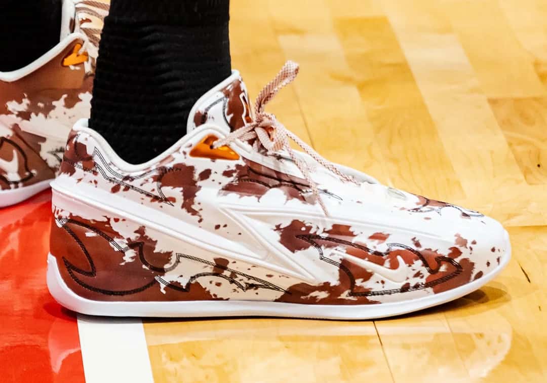 Nike KD 19 Texas de Kevin Durant de perfil, con estampado de vaca marrón y blanco y suela blanca, sobre el parquet