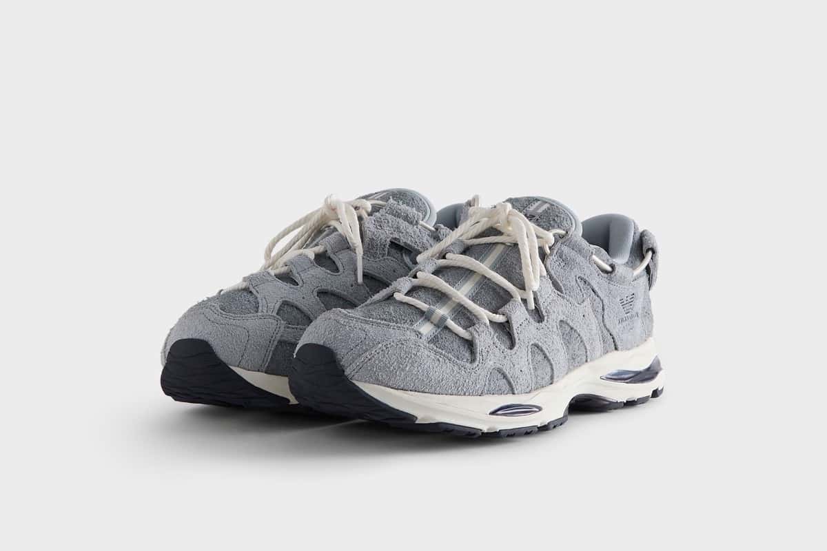 Par de la ASICS GEL-MAI 0.1 Quarry de Giorgio Armani x Kith en diagonal sobre fondo gris claro, con upper de gamuza gris de pelo largo, cordones gruesos tipo soga en color crudo, águila de Giorgio Armani en el lateral y mediasuela blanca con detalles azul marino