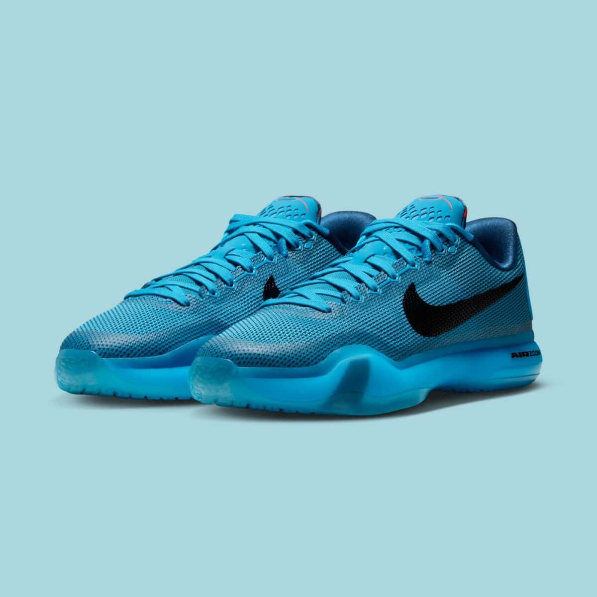 Par de Nike Kobe 10 Protro 5AM Flight en malla azul Blue Lagoon con Swoosh negro y suela azul translúcida sobre fondo celeste