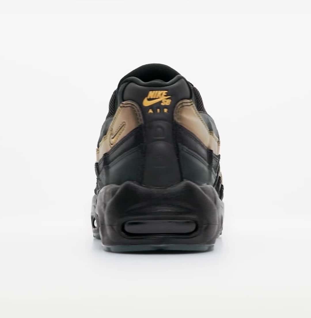 Talón del Kyle Wilson x Nike SB Air Max 95 sobre fondo gris claro, con el logo Nike SB Air en dorado, la franja verde y dorada del costado y la unidad Air oscura